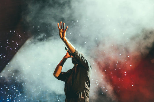 Man singing and raising his hand up to the sky