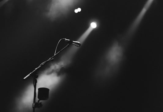 A microphone on a mic stand in the middle of a stage