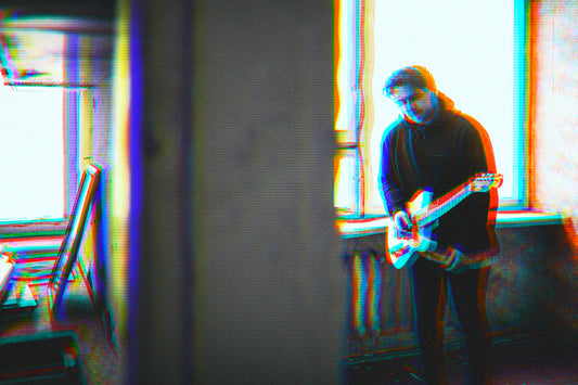 Musician playing electric guitar in a moody, glitch-style setting.