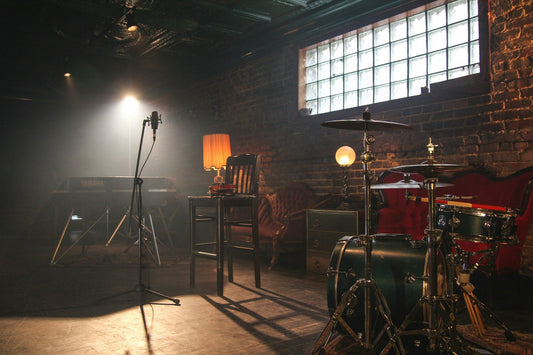 A brick room with lights, drums, and a microphone stand