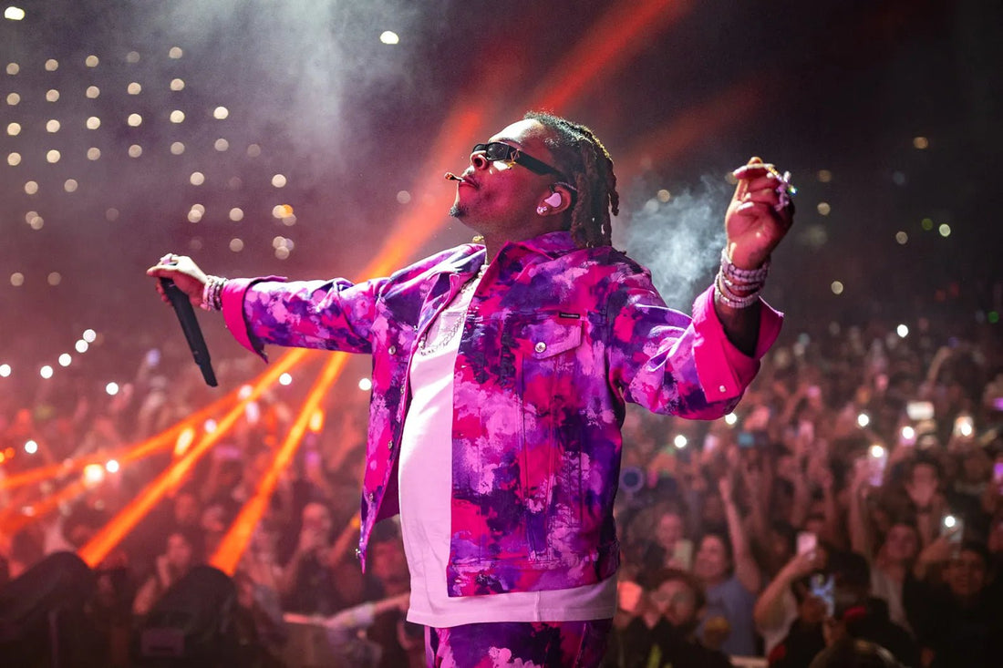Gunna smoking and holding a microphone on stage