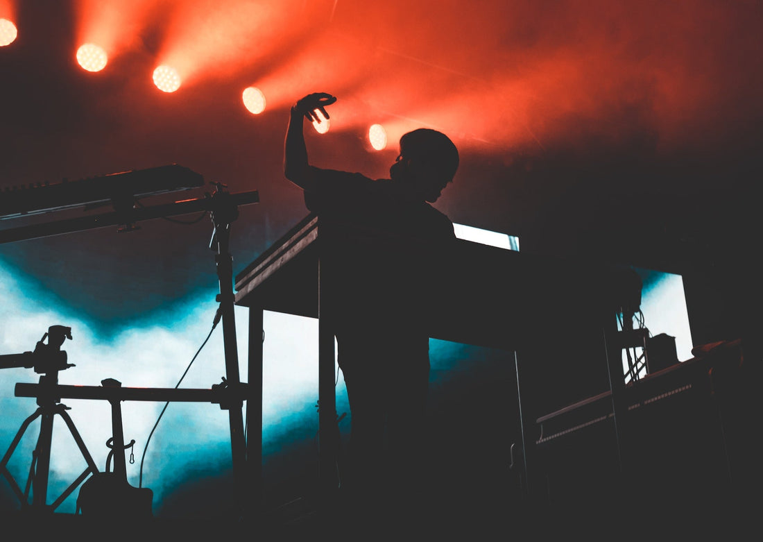 EDM Music artist on a stage with music equipment around them