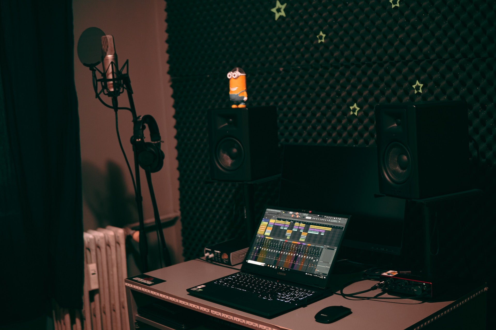FL studio on a laptop in a small home studio room